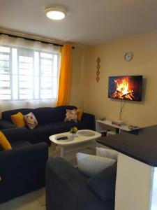 a living room with a couch and a fire on the wall at Ayo's Vacation Home in Thika