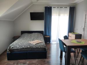ein Schlafzimmer mit einem Bett und einem Esstisch in der Unterkunft 4 Foxes in Ustka