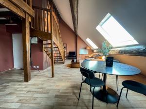 a living room with a table and chairs and a staircase at Casa Andrea - Hypercentre & climatisation in Metz