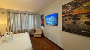a bedroom with a bed and a painting on the wall at HOPE-always in Cape Town