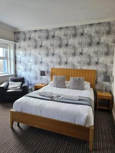 a bedroom with a large bed and a chair at The New Brighton Hotel in New Brighton