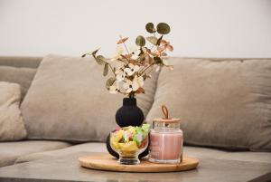 a table with a vase of flowers and a candle at Banus Palace Exclusive in Varaždin