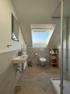 a bathroom with a sink and a toilet and a window at Messe- und Ferienwohnung Feucht in Feucht