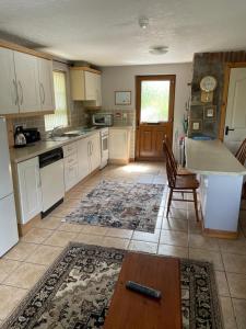 a kitchen with white cabinets and a table at The Slates Apartments - Fuchsia & Orchard Apartments in Irvinestown +5 photos