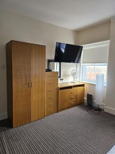 a room with a large wooden cabinet with a flat screen tv at The New Brighton Hotel in New Brighton