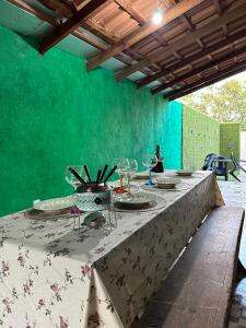 a table with plates on it with a green wall at Woodhouse Tranquilidade e Conforto no Paraíso, piscina aquecida e ar condicionado in Alto Paraíso de Goiás +62 photos