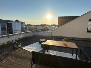 a balcony with a wooden table and a bench at Moderne Wohnung mit Dachterrasse in Groß-Umstadt