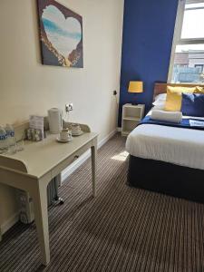 a room with a desk and a bed and a bed and a table at The New Brighton Hotel in New Brighton
