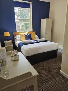 a bedroom with a large bed and a window at The New Brighton Hotel in New Brighton