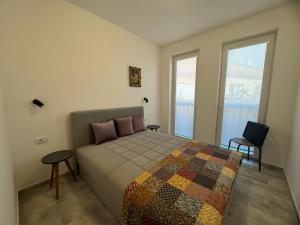 1 dormitorio con 1 cama con 2 mesas y 2 ventanas en Vas Dom, en Soko Banja