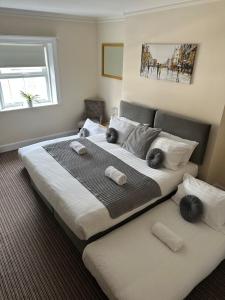 a bedroom with a large bed with towels on it at The New Brighton Hotel in New Brighton