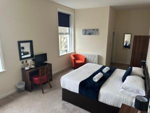 a bedroom with a bed and a desk and a chair at The New Brighton Hotel in New Brighton