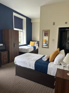 a hotel room with two beds and a mirror at The New Brighton Hotel in New Brighton