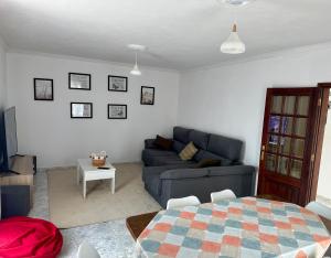 a living room with a blue couch and a table at Sweet Home in Miranda do Douro