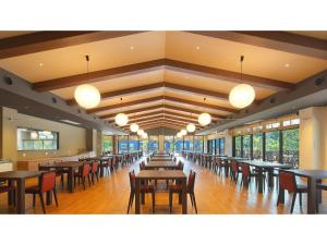 a dining room with tables and chairs and windows at Aso Hakuun Sanso - Vacation STAY 77833v in Aso