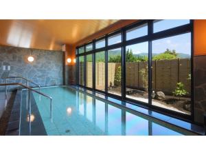 a large swimming pool in a house with windows at Aso Hakuun Sanso - Vacation STAY 77833v in Aso