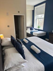 two beds in a room with blue walls at The New Brighton Hotel in New Brighton