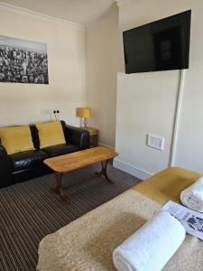 a living room with a couch and a table at The New Brighton Hotel in New Brighton