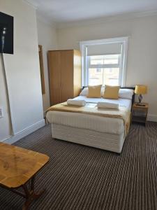 a bedroom with a bed with pillows and a window at The New Brighton Hotel in New Brighton
