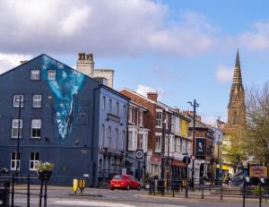 a building with a painting on the side of it on a city street at The New Brighton Hotel in New Brighton