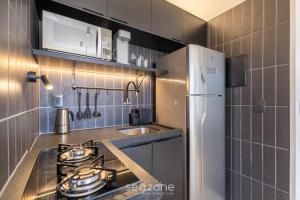 a small kitchen with a stove and a refrigerator at Studio Moderno em Lago Norte SHL0105 in Brasilia