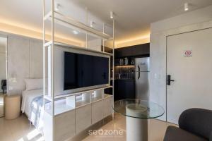 a living room with a tv and a glass table at Studio Moderno em Lago Norte SHL0105 in Brasilia