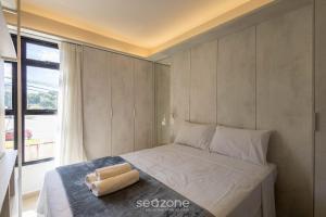 a bed with two towels on it in a bedroom at Studio Moderno em Lago Norte SHL0105 in Brasilia