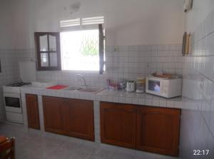 a kitchen with a sink and a stove and a window at Chez Tatie Juju in Sainte-Anne