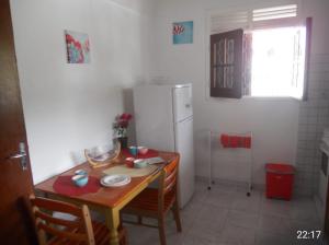 une petite cuisine avec une table et un réfrigérateur dans l'établissement Chez Tatie Juju, à Sainte-Anne