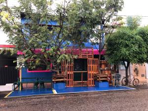 a blue building with a tree in front of it at Hostel e pousada paz e benção in Mossoró