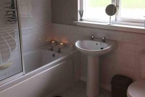 a bathroom with a sink and a bath tub and a sink at Fraoch, Pets welcome in Port Bannatyne +38 photos
