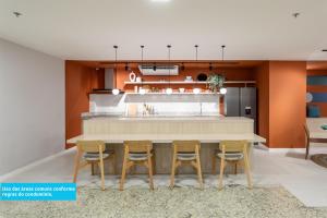 a kitchen with a counter with four chairs around it at Lobie Casa Mauá in Rio de Janeiro +18 photos