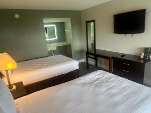 Una habitación de hotel con dos camas y un televisor de pantalla plana. en Rodeway Inn Davenport-Champions Gate, en Davenport