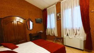a bedroom with a bed and two windows and a television at Agriturismo Eva - Venice Airport in Favaro Veneto