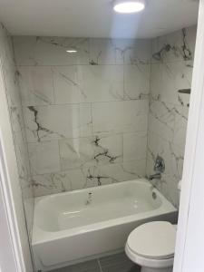 Un baño blanco con bañera y inodoro. en Rodeway Inn Davenport-Champions Gate, en Davenport
