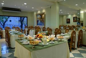 a dining room with tables and chairs with food on them at Hotel Ariosto in Mendoza