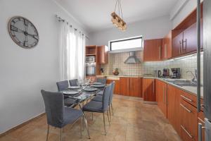 a kitchen with a table and chairs and a clock at Koskinou Residence in Koskinou