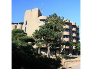a large building with a tree in front of it at Hotel Tetra Resort Shizuoka Yaizu - Vacation STAY 35243v in Yaizu