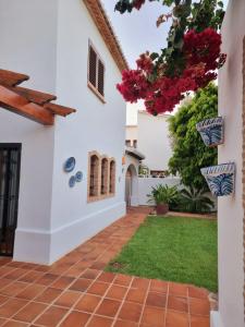 a courtyard of a house with pink flowers at Casa La Marina in Denia