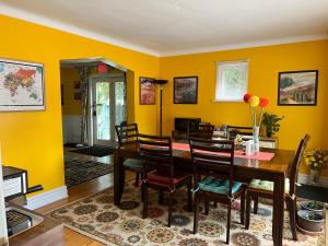 a dining room with yellow walls and a table and chairs at Cozy House B&B in Niagara Falls