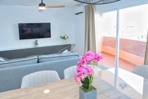 a living room with a table with flowers on it at Coin Premium San Cristobal in Coín