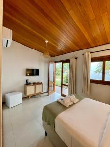a bedroom with a large bed and a television at Pousada Calmar in Praia do Rosa +80 photos