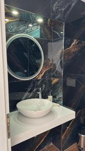 a bathroom with a sink and a mirror at Lumra Rooms in Lukov&euml;