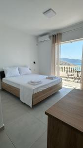 a bedroom with a large bed and a large window at Lumra Rooms in Lukov&euml;