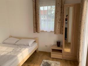 a bedroom with a bed and a window and a mirror at ZIELONA DOLINA - kompleks dla rodzin z dziećmi in Mikołajki +32 photos