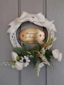 a wreath with a sign on a door with flowers at L'Angolo di Firenze - The Florence Corner in Florence