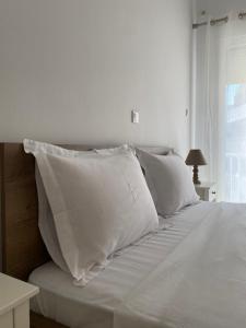 ein weißes Bett mit weißen Laken und Kissen in der Unterkunft Central in Chalkida