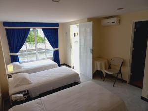 a hotel room with three beds and a window at Hotel Oasys Blue in Roldanillo