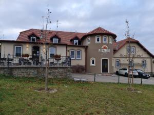 budynek z zaparkowanym przed nim samochodem w obiekcie Hotel & Restaurace Pizzerie Jasany w Znojmie