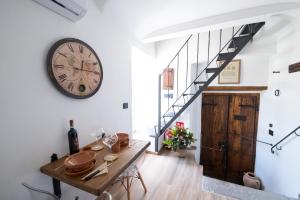 a dining room with a table and a clock on the wall at 19 Antico Granaio in Ronciglione